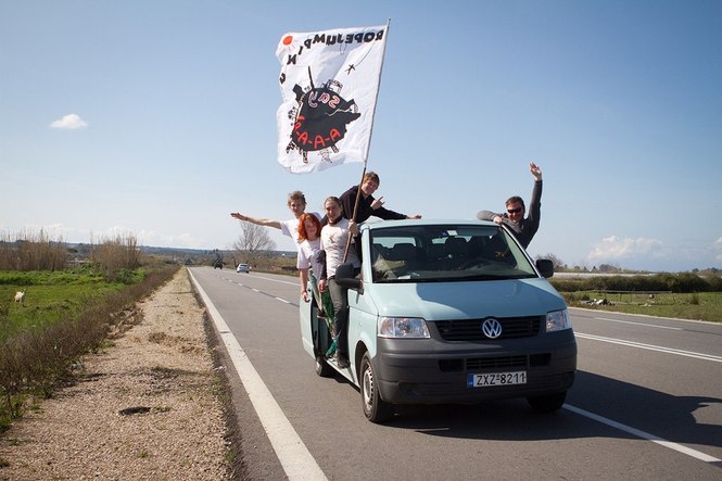Закинтос - команда в фургоне едет по шоссе с флагом
